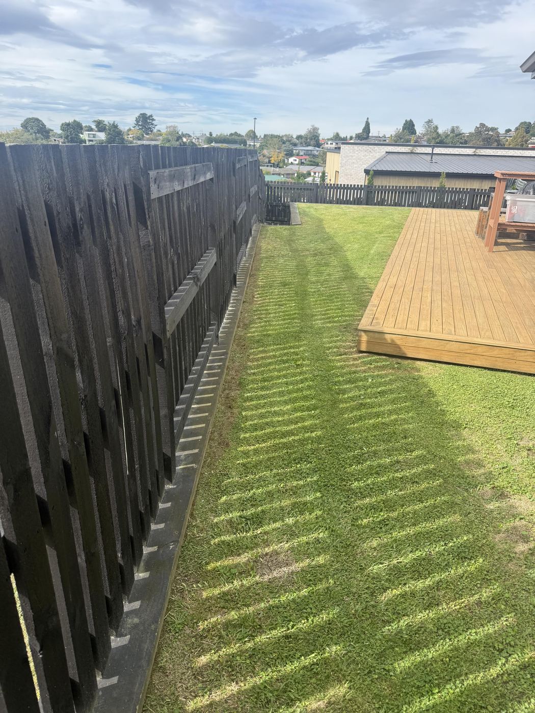 Lawn edging along a deck by JR Lawn Mowing