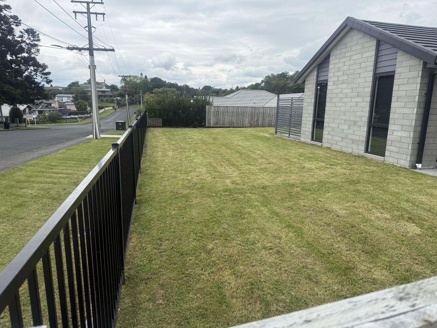 Freshly cut lawn in a fenced yard by JR Lawn Mowing