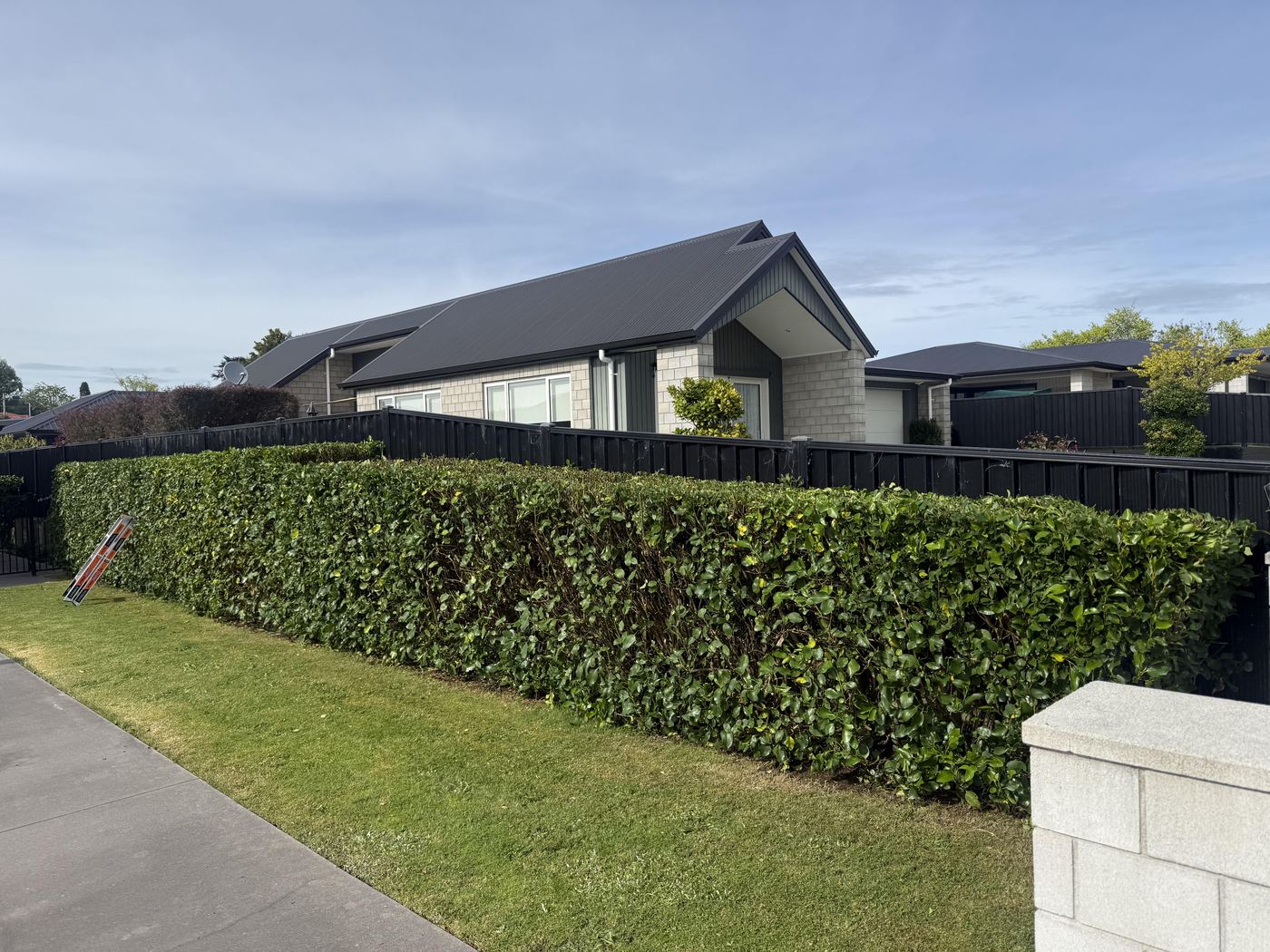 Neatly trimmed front yard hedge by JR Lawn Mowing